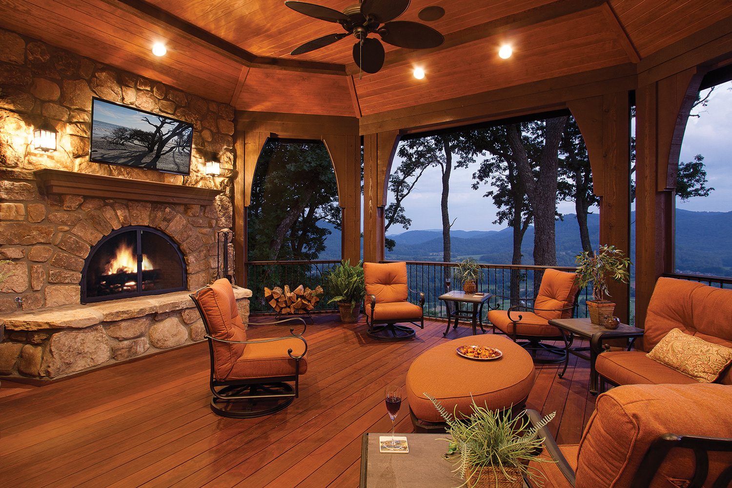 Several overlooks from the back of the house are designed for more than a passing moment. The screened-in porch is a favorite. Curved brackets frame an expansive view of the surrounding mountainous terrain. Folding doors open to the kitchen, doubling the size for entertaining. Ipe, a lush hardwood known for its durability, completes the decking and an exterior fireplace adds ambiance. Photo by J. Weiland